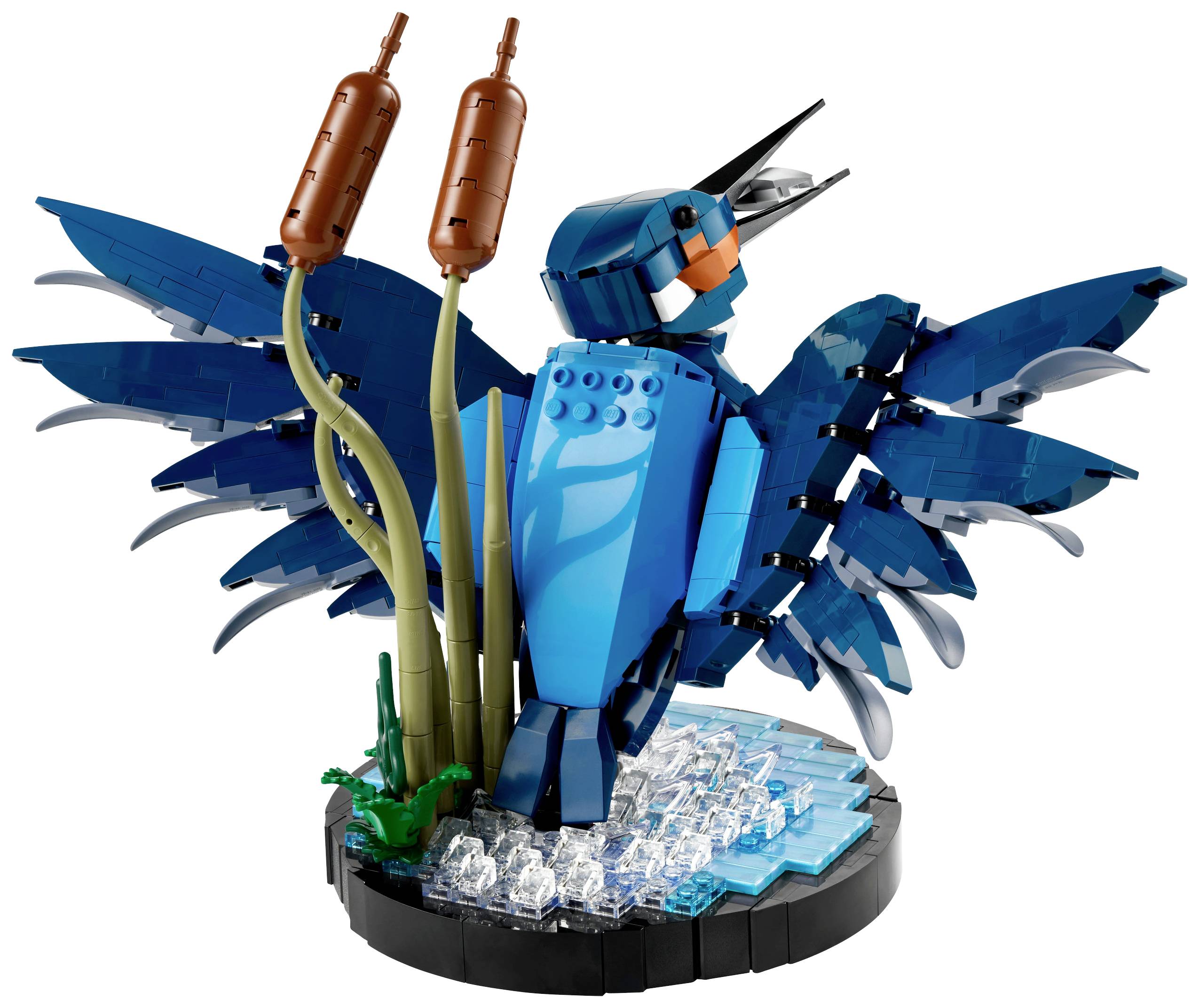 A blue Lego bird with outstretched wings stands on a base of transparent bricks next to two reed stems.