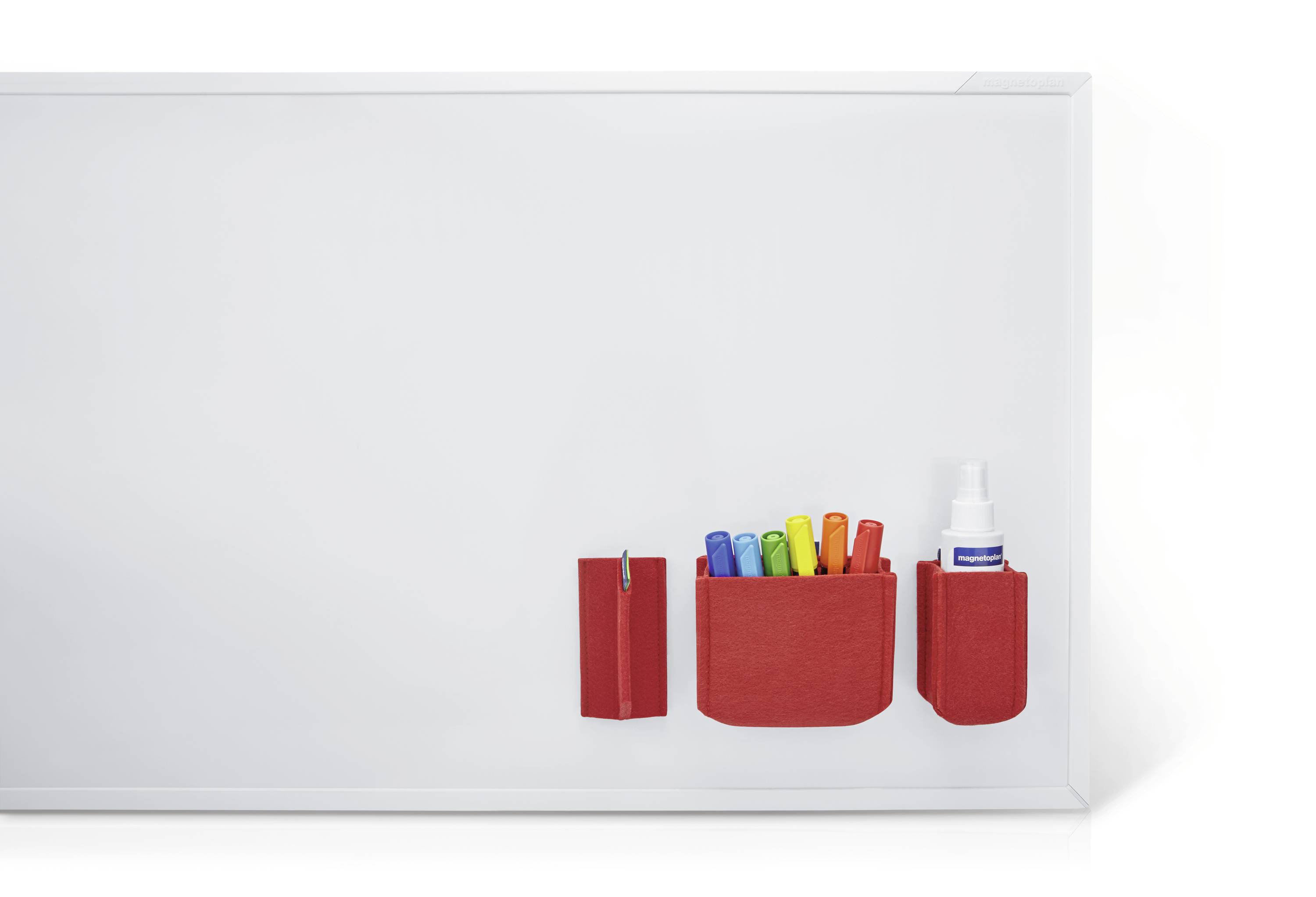 Blackboard with red holders containing colourful pens and a bottle brush.