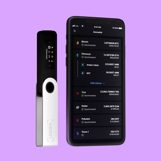 A black hardware wallet device next to a smartphone with a crypto wallet app on a purple background.