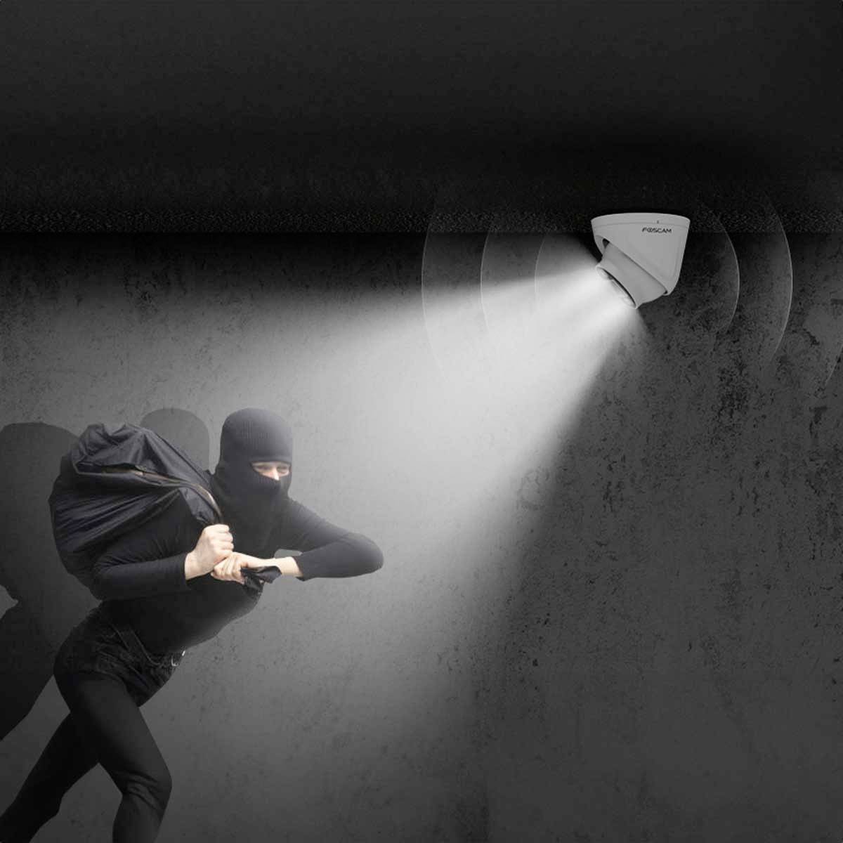 A masked burglar moves in the light of an activated motion sensor mounted on the ceiling.