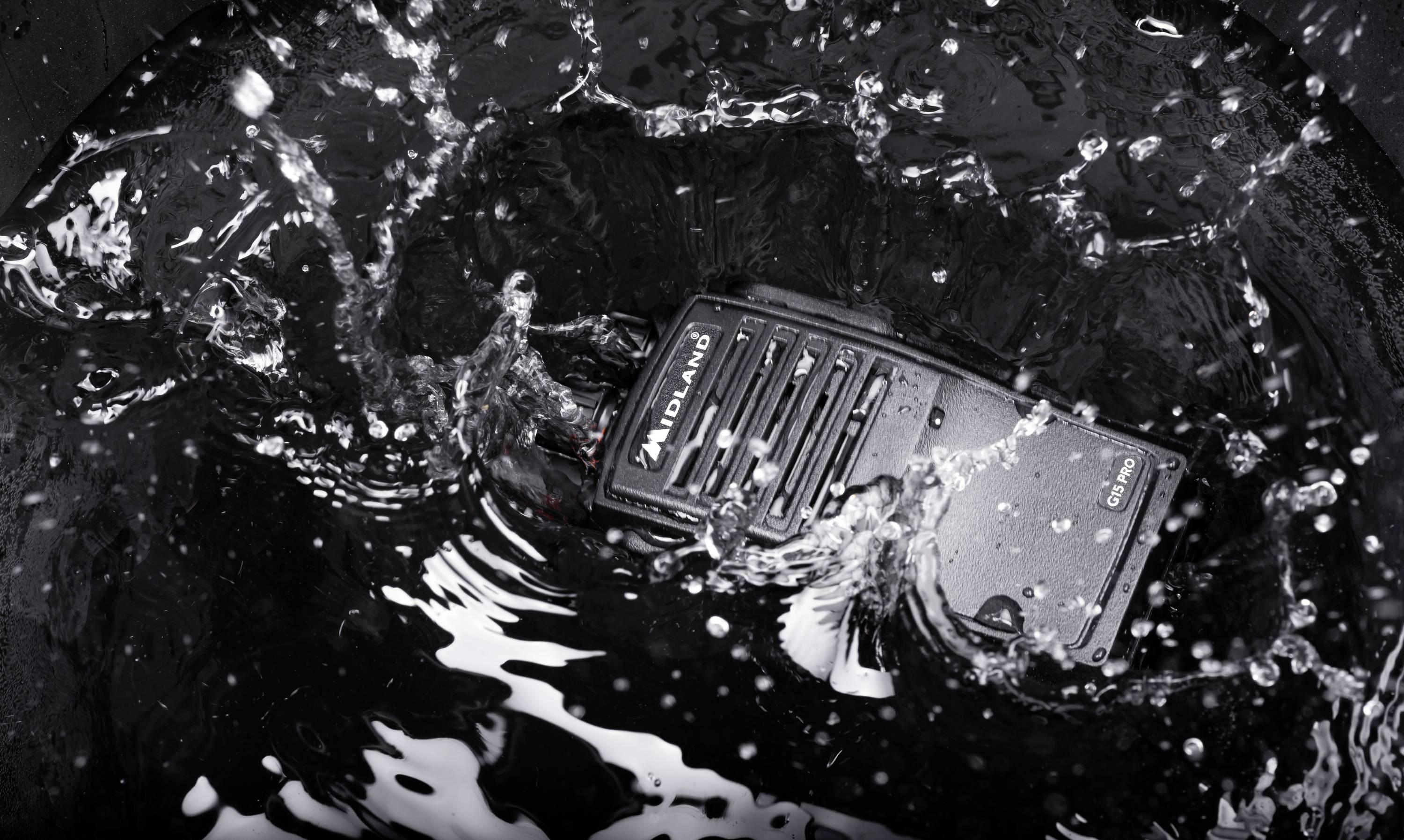 A radio lies in splashing water, indicating its water resistance.