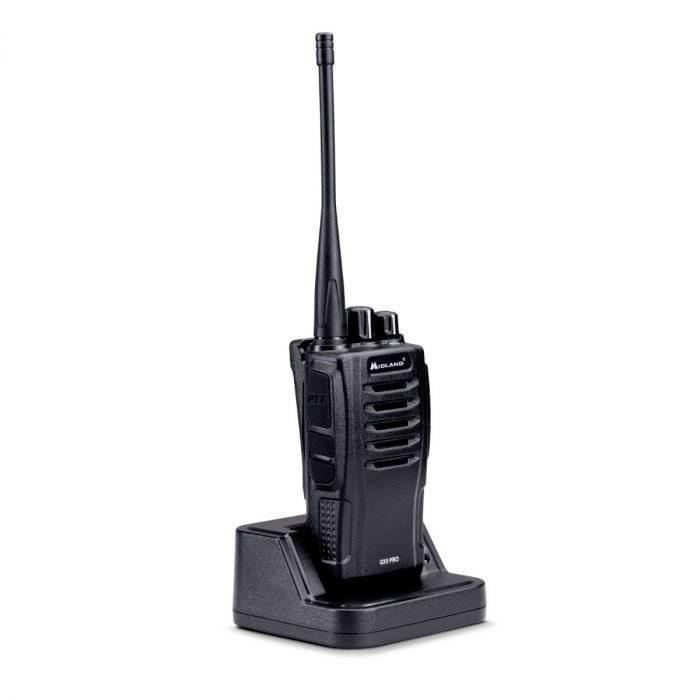 Black handheld radio sits on a charging station. It has a long antenna and side-mounted speaking and volume buttons.