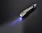A torch pen lies on a dark background. It is emitting a blue light from its lens.
