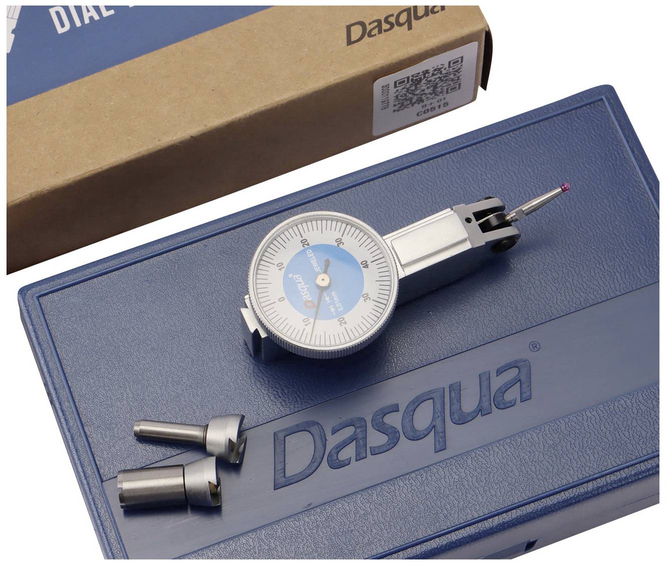 Analogue measuring device on a blue box with 'Dasqua' inscription. Two metal tips beside it. Packaging in the background.