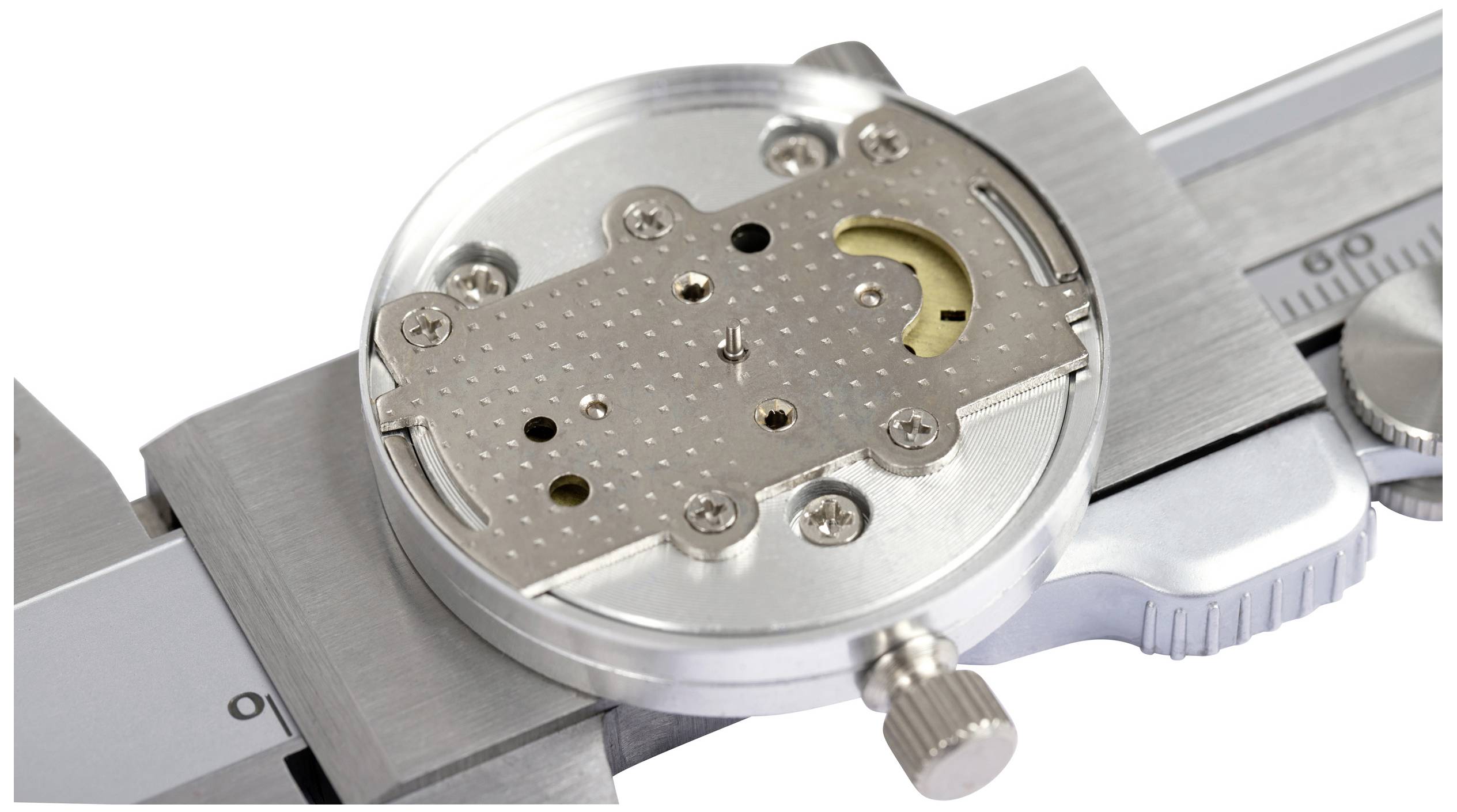 A vernier calliper with a metal plate between the measuring jaws. The plate has holes and screws, possibly part of a clockwork mechanism.