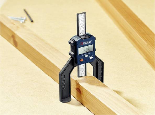 A digital measuring device is measuring the width of a piece of wood. The screen displays '46.85'. Screws are visible in the background.