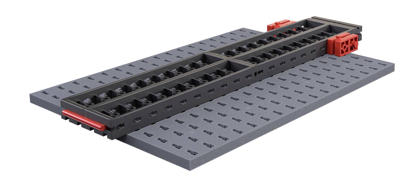 'A Technic Lego piece placed on a grey baseplate, showing a complex structure made of black and red bricks.'