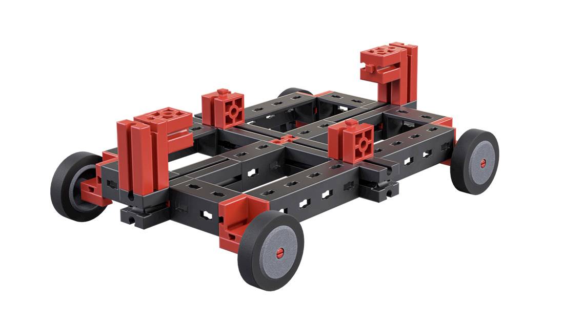 A modular chassis model with four wheels, featuring black and red components, which serves as a base for various constructions.