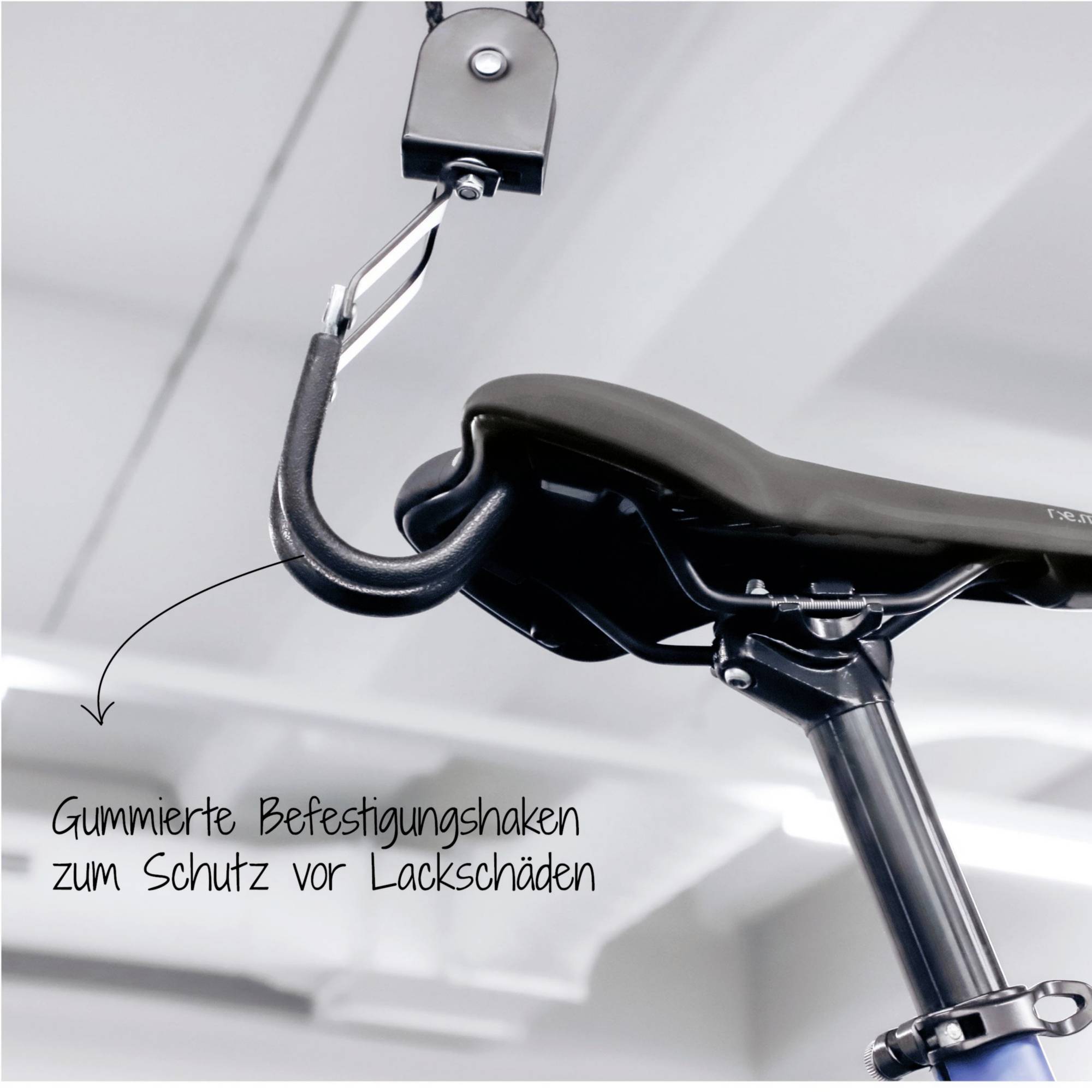 'Rubber-coated mounting hooks to prevent paint damage' is attached to the bicycle frame; it is hanging from a hook on the ceiling.