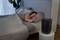 A person is sleeping in a bed in a bedroom. An air purifier is standing on a table next to the bed.