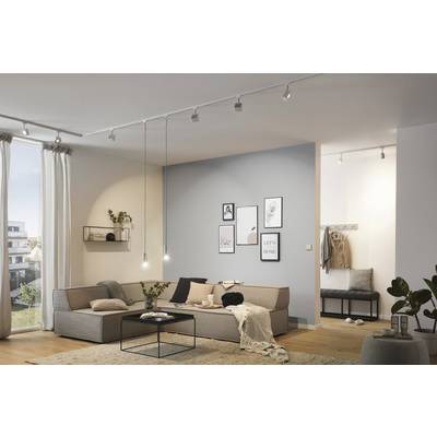Bright living room with a modern sofa, coffee table and decorative pictures on the wall. Large windows allow plenty of light to enter.