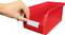 A hand is inserting a label into a red storage box with an open compartment.