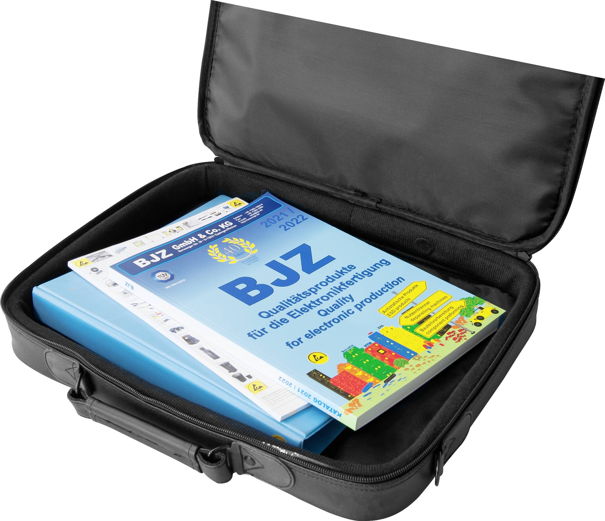 A black bag contains professional journals on quality assurance in electronic production.