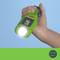 A hand is holding a green LED torch, which is shining brightly. The lamp displays "120 lm" on a green background.