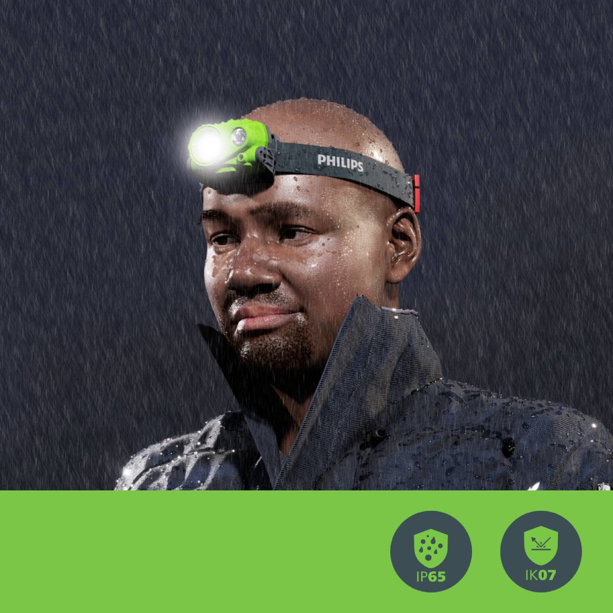 A person is wearing a Philips head torch in the rain. The clothing is weatherproof. Below are symbols for IP65 and IK07 protection.