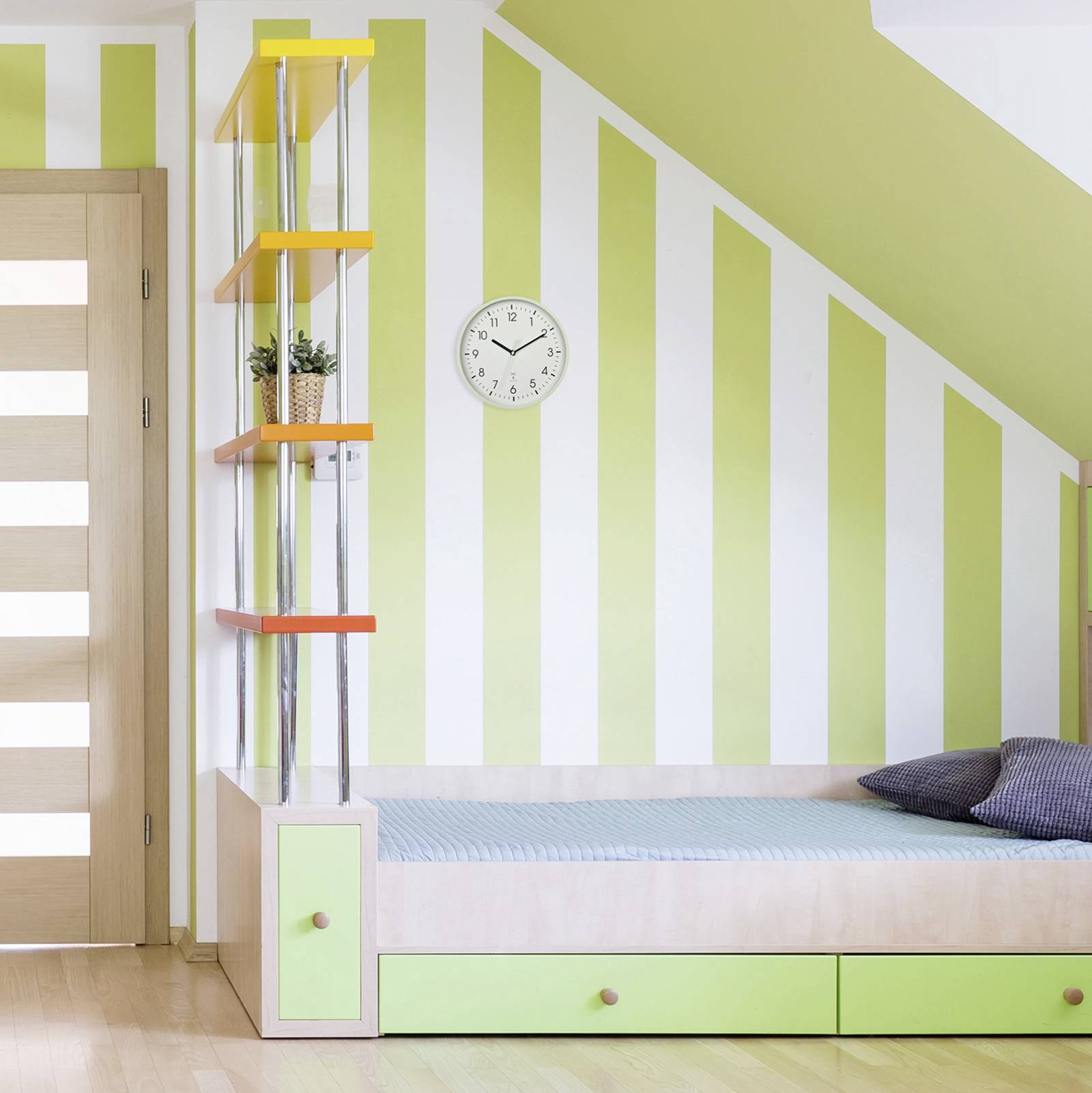 A children's bedroom with green and white striped walls, a bed with storage, a wall clock, and a shelf with plants.