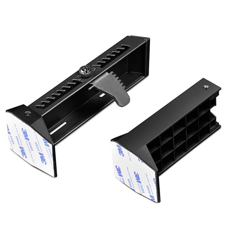 Two black rectangular plastic parts with adhesive pads, one with an adjustable mechanism and teeth-like design, suitable for fastening.