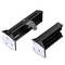 Two black rectangular plastic parts with adhesive pads, one with an adjustable mechanism and teeth-like design, suitable for fastening.