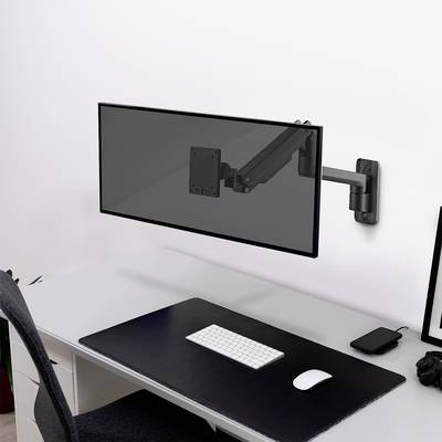 A tidy desk with a keyboard, mouse and a monitor arm without a monitor, all in a modern, minimalist design.