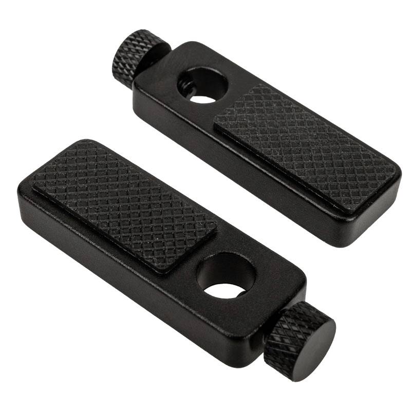 Two black, rectangular metal plates with a ribbed surface and round recesses, connected by knurled screws.