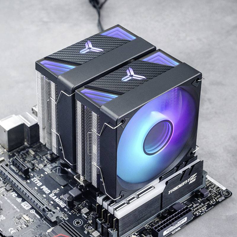 Large CPU air cooler with two fans installed on a motherboard. Fans are illuminated in colourful LED colours.