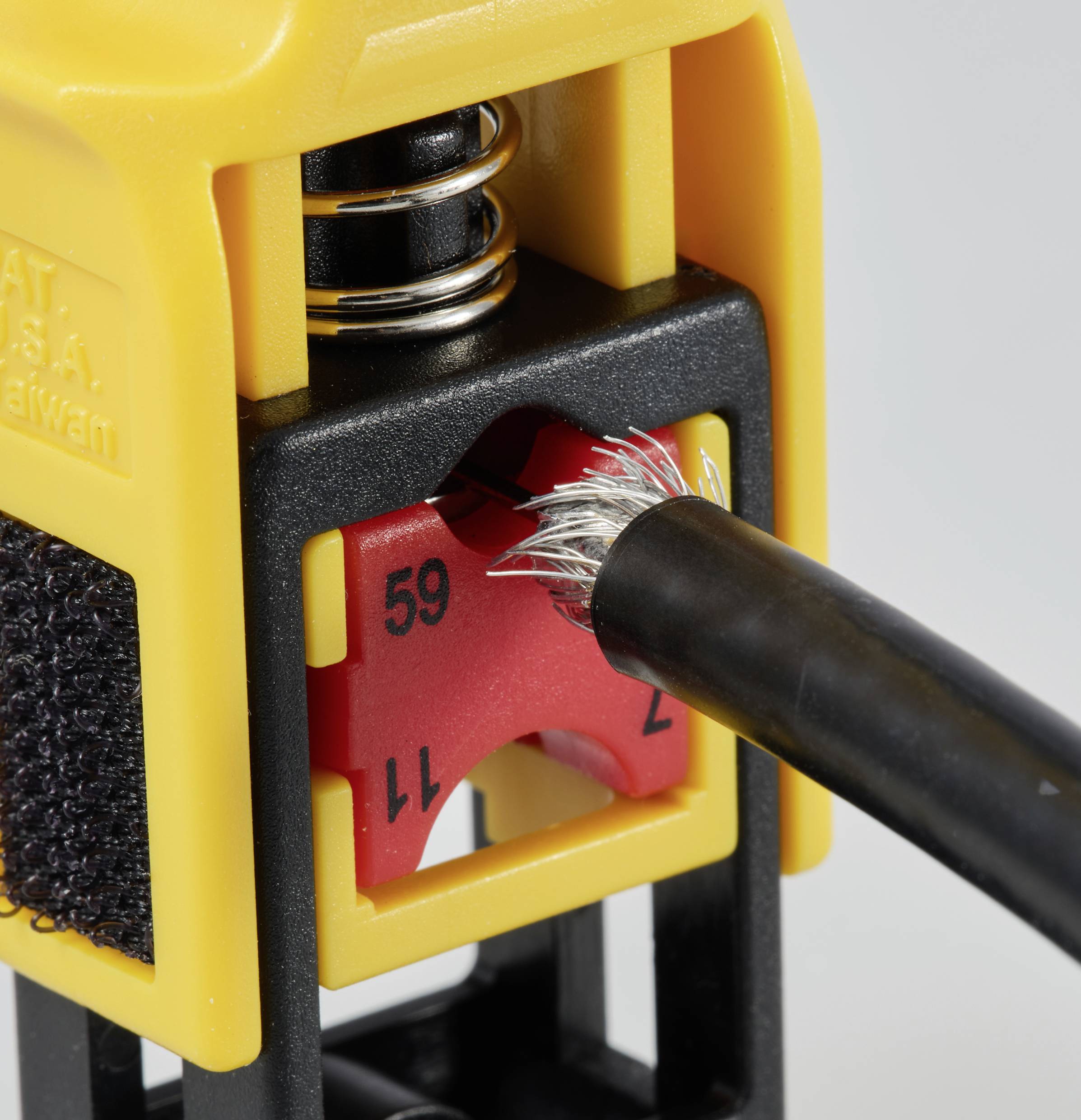 An electric cable stripper removes the insulation from a cable. A red number wheel displays the number 59.
