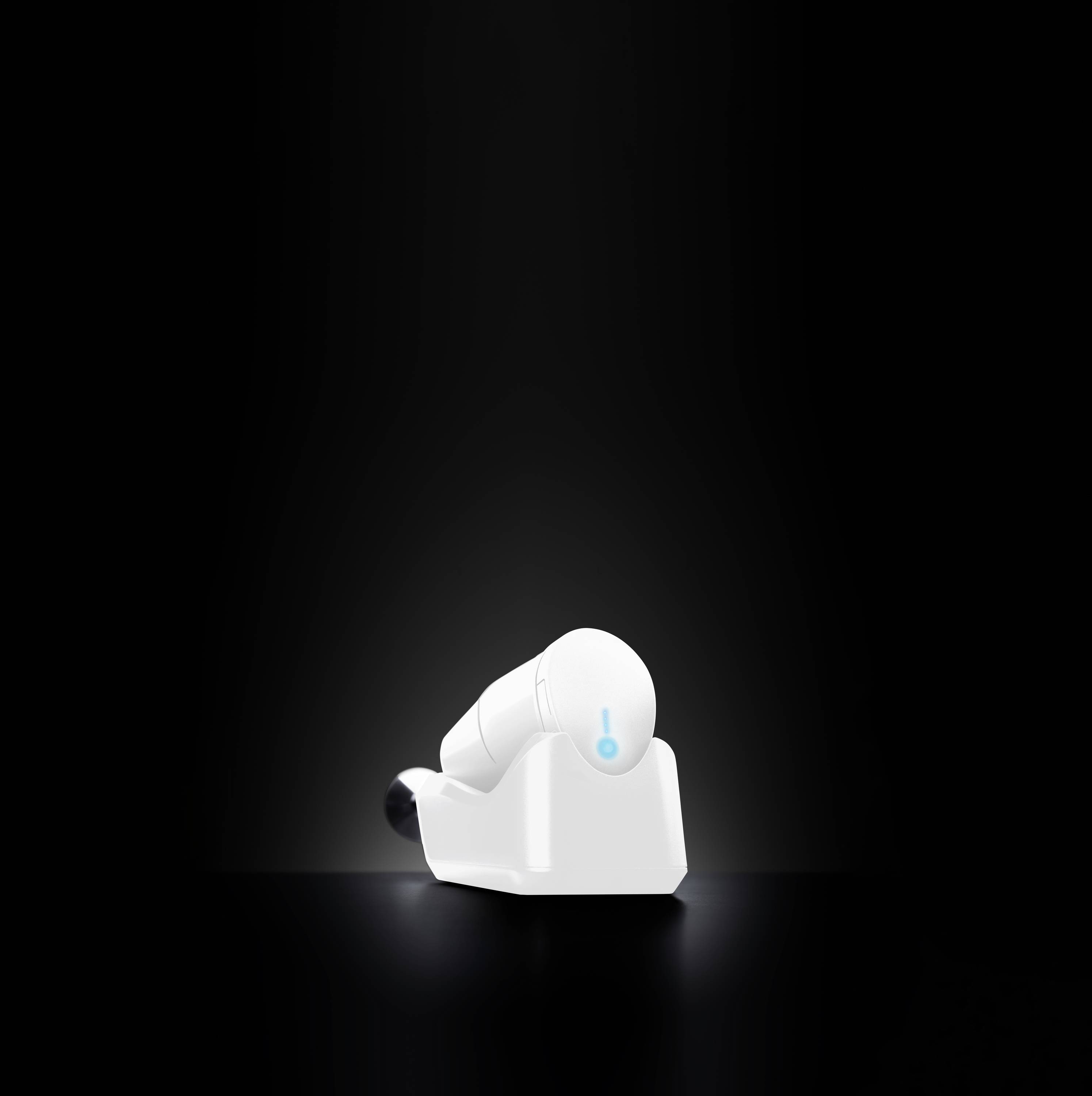 A white, wireless earphone set glows softly in a dark room. The charging case holds the earphones securely.