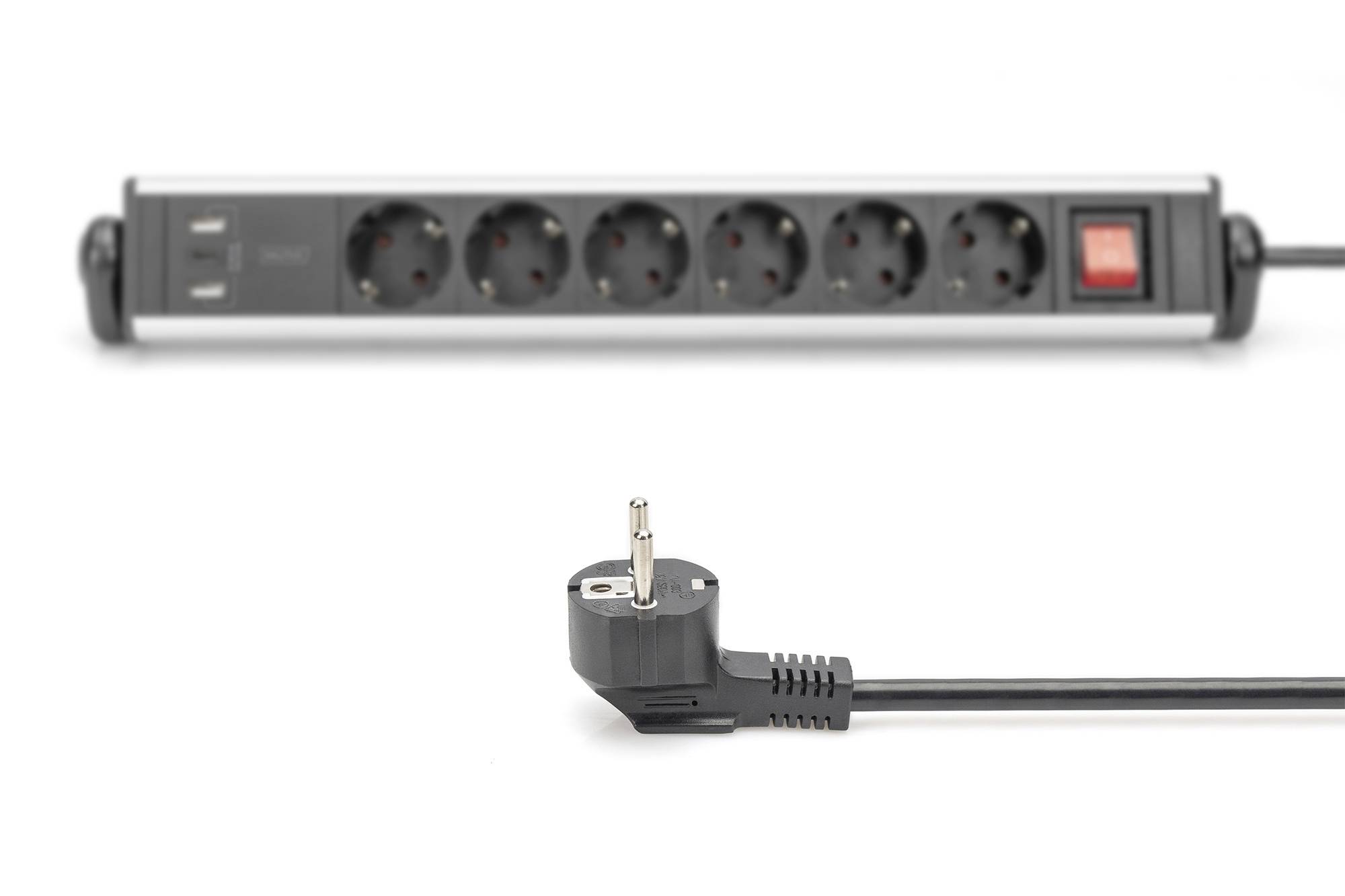 Power strip with six socket outlets and USB ports in the background; a European mains plug in the foreground.