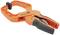 Orange spring clamp with a black handle, inscribed with 'Pony', used for holding materials together during woodworking.