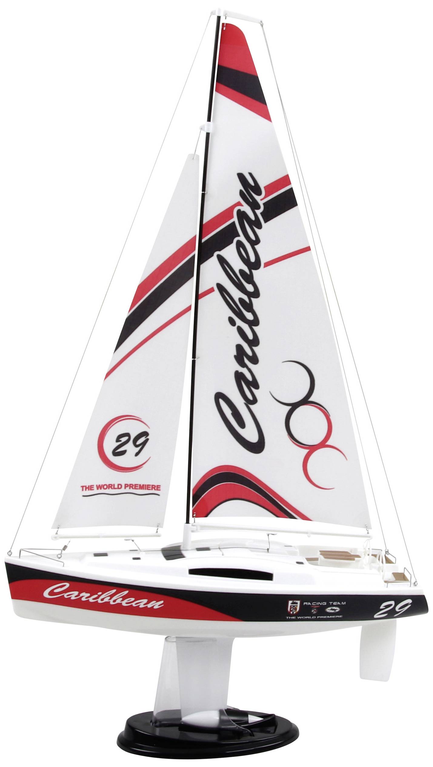 A model sailing boat with a white hull and red details. The name 'Caribbean' is written on the sail. The boat stands on a black base.