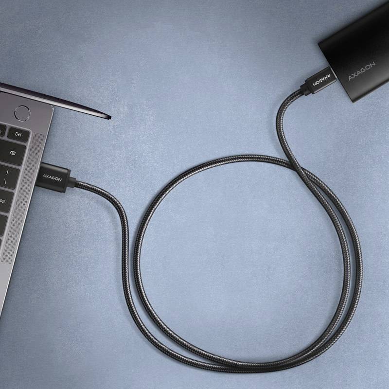Laptop with a USB stick connected on the left-hand side. On the right-hand side, another USB cable is connected.