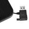 A black, rectangular USB charger with a short cable and a USB plug, partially sheathed, rests on a white background.