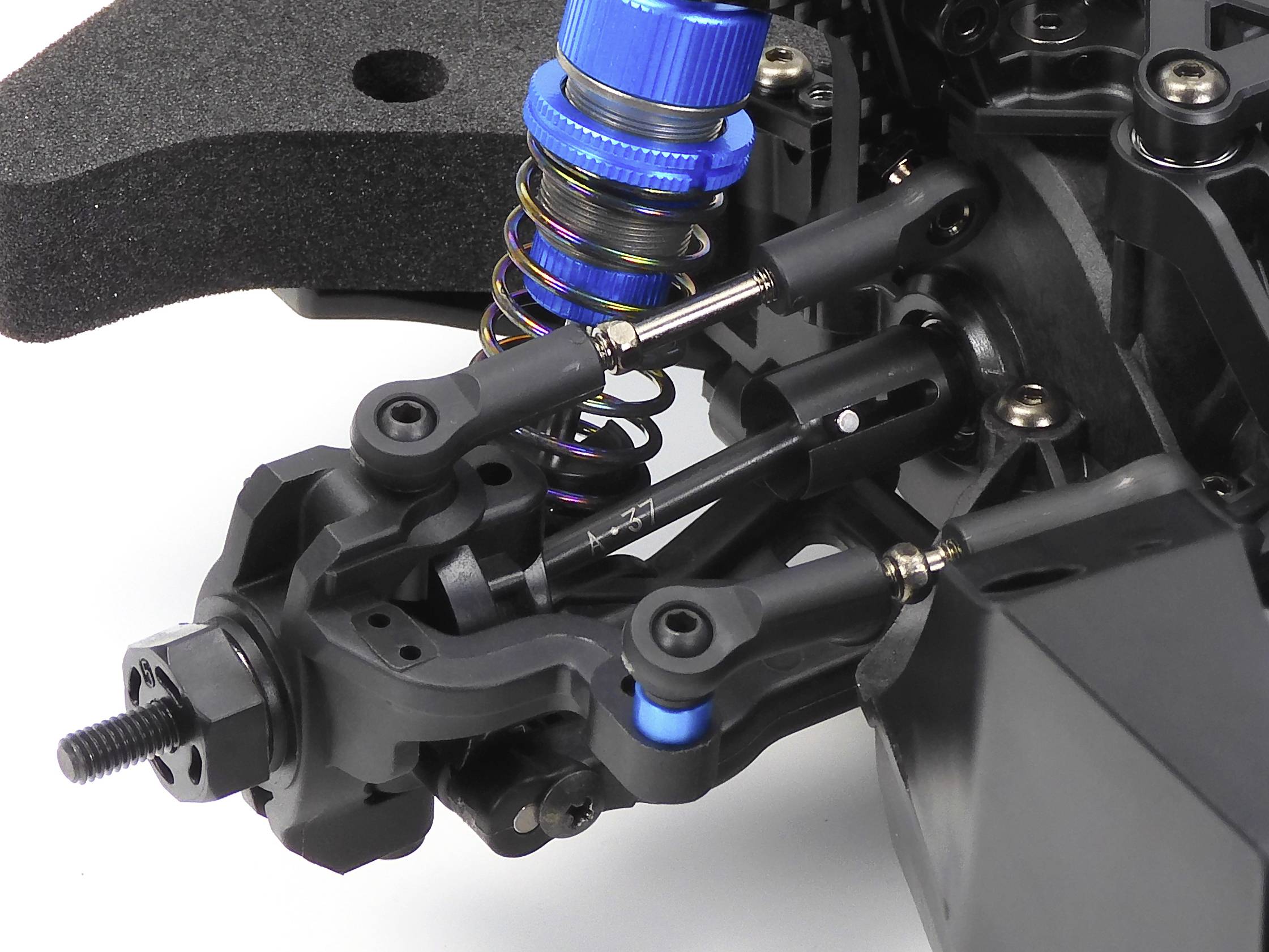 Close-up of a blue shock absorber on a black technical device, possibly an internal component of a model vehicle.