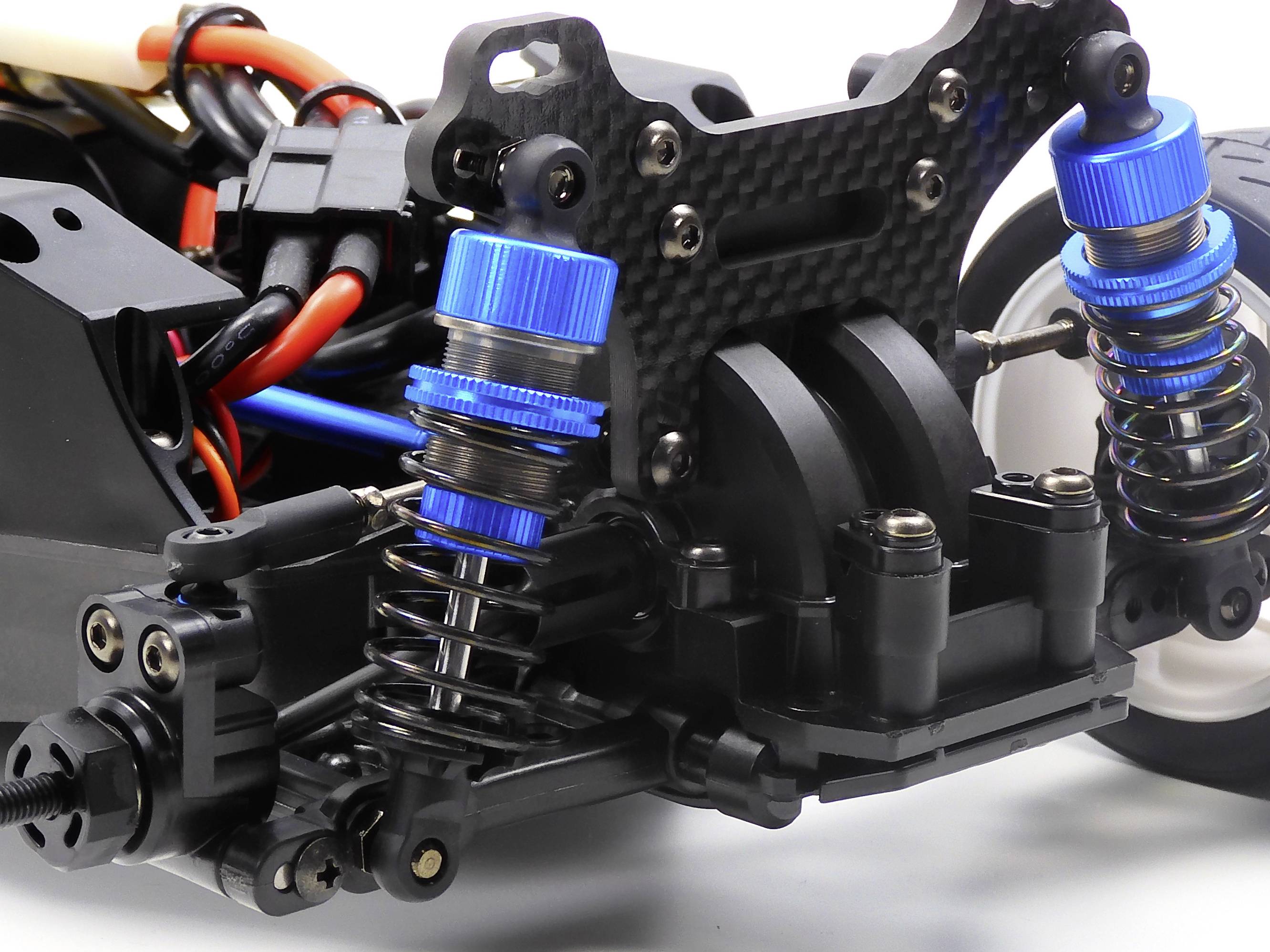 Close-up of a remote-controlled car suspension with blue shock absorbers, spring-loaded dampers, and wiring in the background.