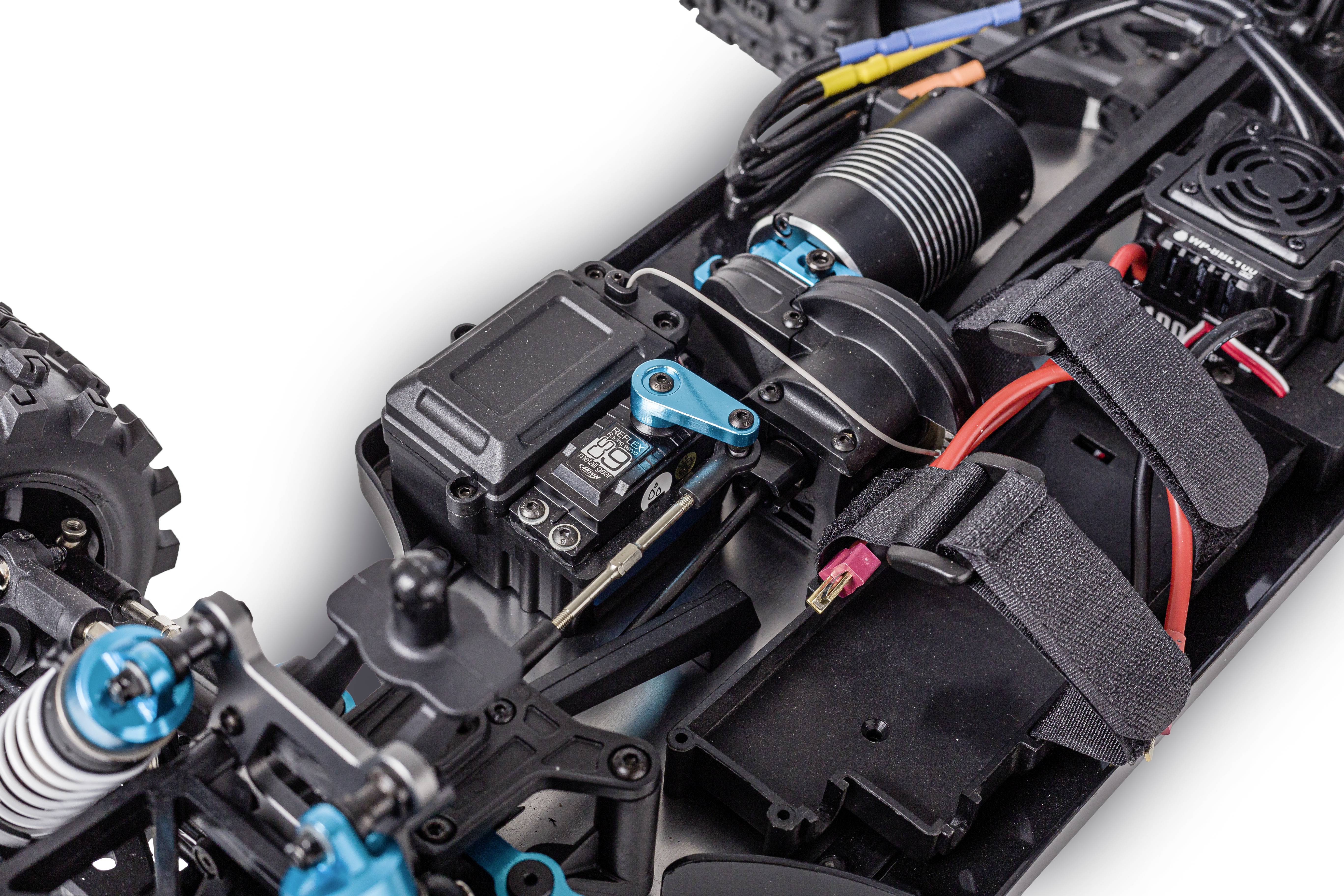 Close-up of RC car components, showing the motor, electronics, and wiring. Focus on drive components and their arrangement.