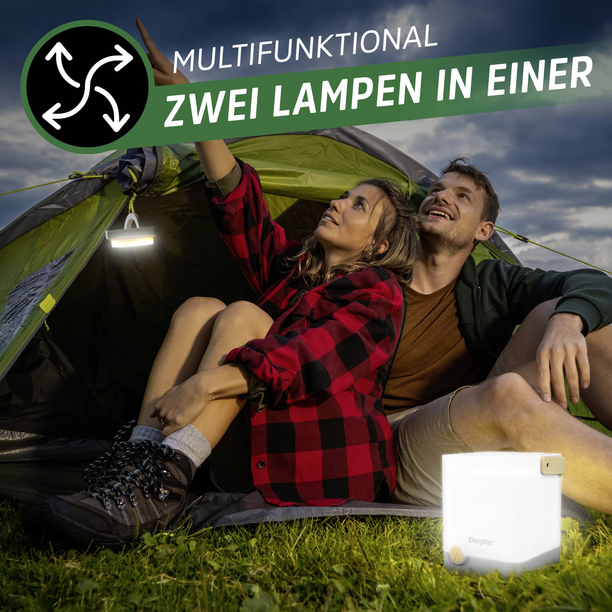 'Multifunctional: Two Lamps in One.' A couple sits happily in front of a tent with a torch in the foreground.<br><br>Note: I replaced "Taschenlampe" with "torch", which is the standard British English term, instead of the American "flashlight".