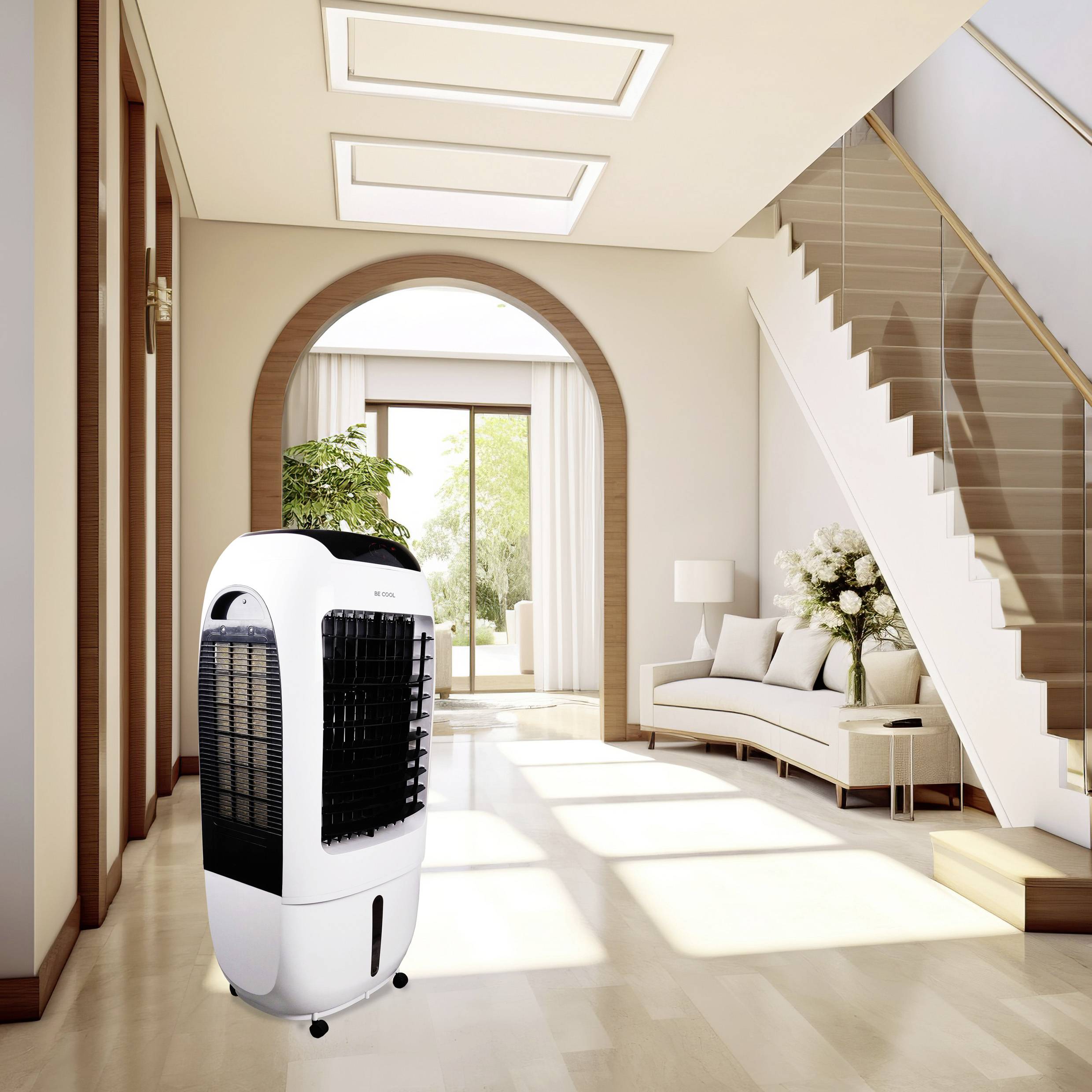 Portable air cooler on a light wooden floor in a modern living room. In the background, there is a sofa and a staircase.