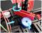 A technical model with rotating and sliding components. A red mechanism rotates while a blue cylinder is translated.