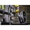 A worker wearing yellow gloves is using a tool to drill a hole with a core drill bit into a piece of metal.