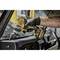 A hand wearing a black glove holds a yellow cordless drill and tightens screws inside a vehicle's interior.