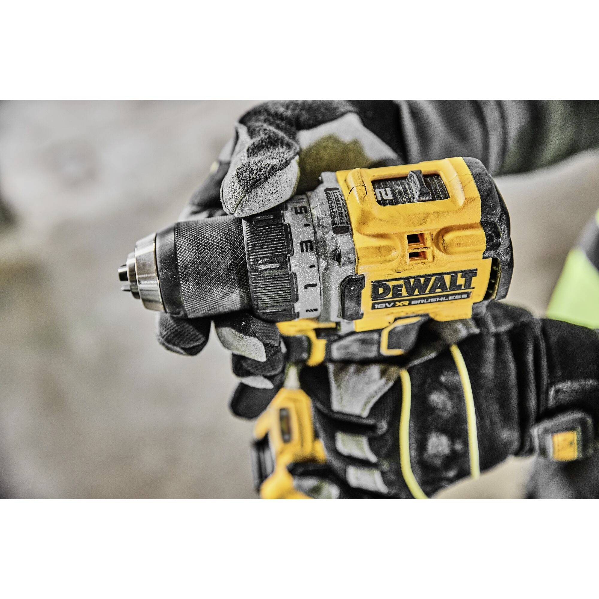 Close-up of a tradesman holding a yellow cordless drill. Focus on tool brand and handling.