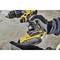 A person is holding a yellow cordless drill with an 18V battery. The glove protects the hand during work. The focus is on the tool.