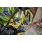 A person is wearing gloves and holding a yellow electric hand drill, ready for use on a construction site.