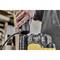 A person is plugging a plug into a yellow industrial vacuum cleaner. The focus is on the hand and the plug.