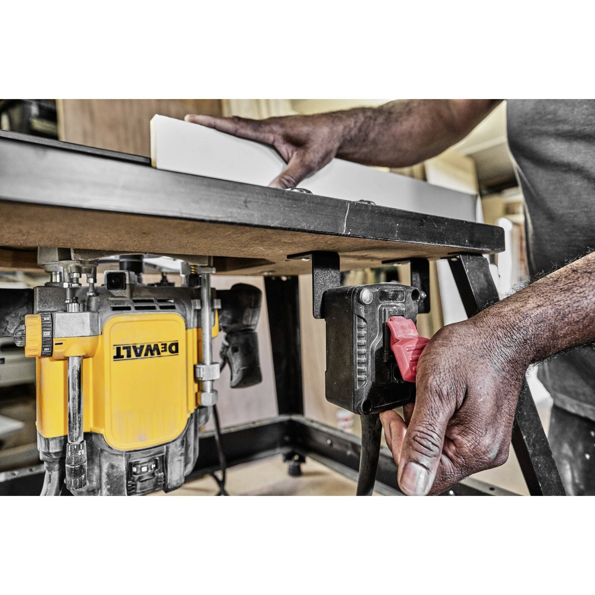 A person is working with a piece of wood and a table circular saw in a workshop. Tools and materials are visible.
