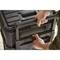 'Close-up of two hands lifting the handle of a large, black wheeled transport case.'
