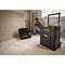 A man is sitting on the ground in a renovated room, next to two black Stanley tool cases.