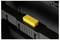 Yellow 'PUSH' button on a black suitcase. The button is centrally positioned and used for opening or closing the suitcase.