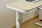 Wooden table with a laptop, with headphones hanging on a hook at the edge of the table.