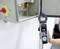 A person uses a clamp meter to measure the current flowing through a wire in an electrical panel, showing a reading of 0.485.